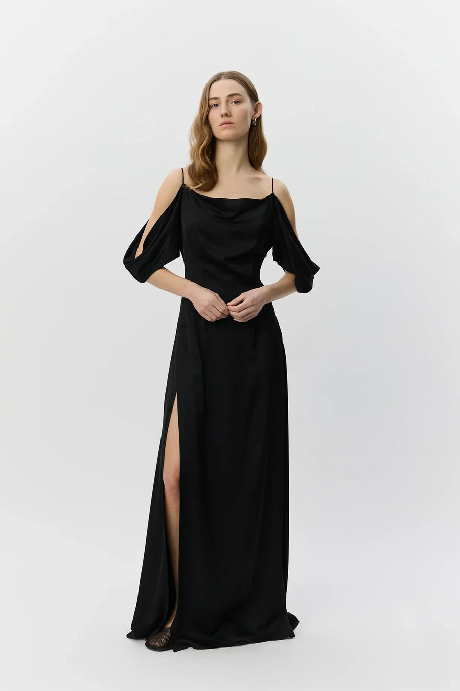 Woman wearing a black evening gown with cut-out sleeves on a white background