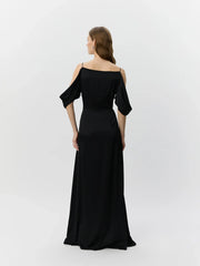 Woman wearing a black off-shoulder dress on a white background