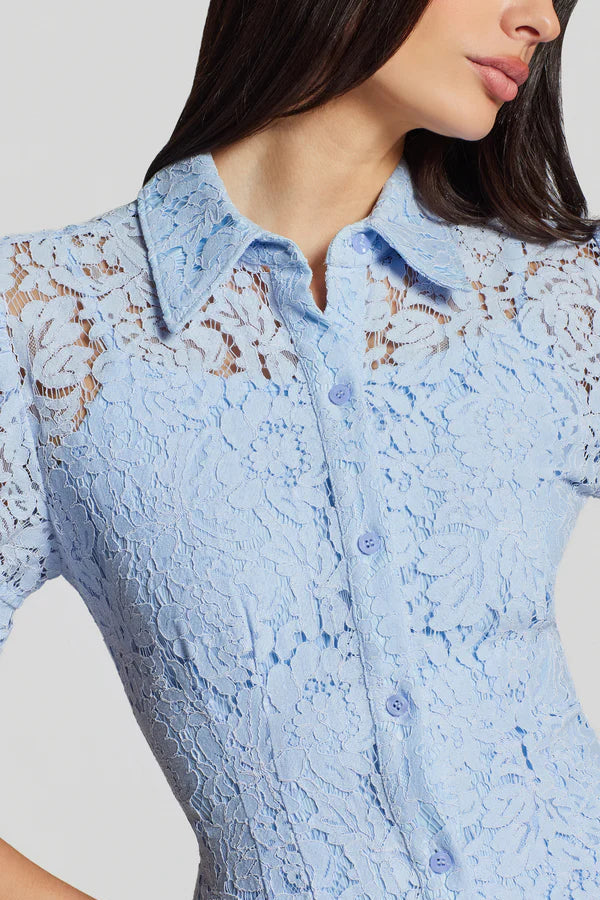 woman wearing a light blue short-sleeve lace mini dress with a collar and button-front design, detail