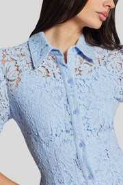 woman wearing a light blue short-sleeve lace mini dress with a collar and button-front design, detail