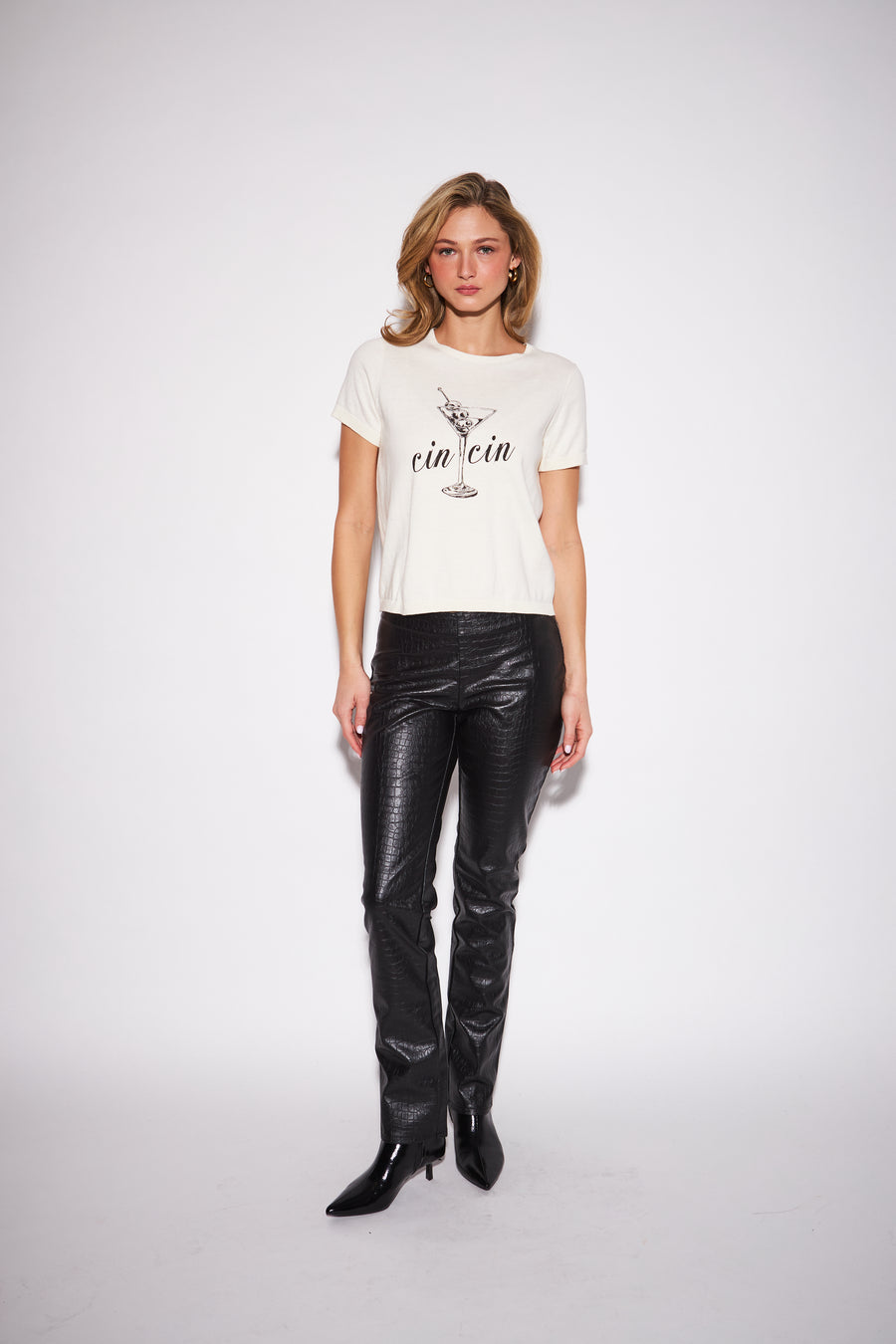 model wearing a white graphic crew neck T-shirt with black script lettering paired with black script lettering