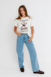 woman wearing white graphic tee with blue jeans