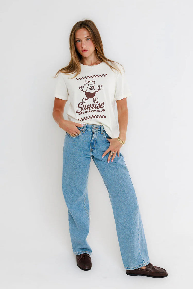 woman wearing white graphic tee with blue jeans