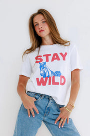Woman wearing a white t-shirt with a horse and the text 'Stay Wild' graphic 