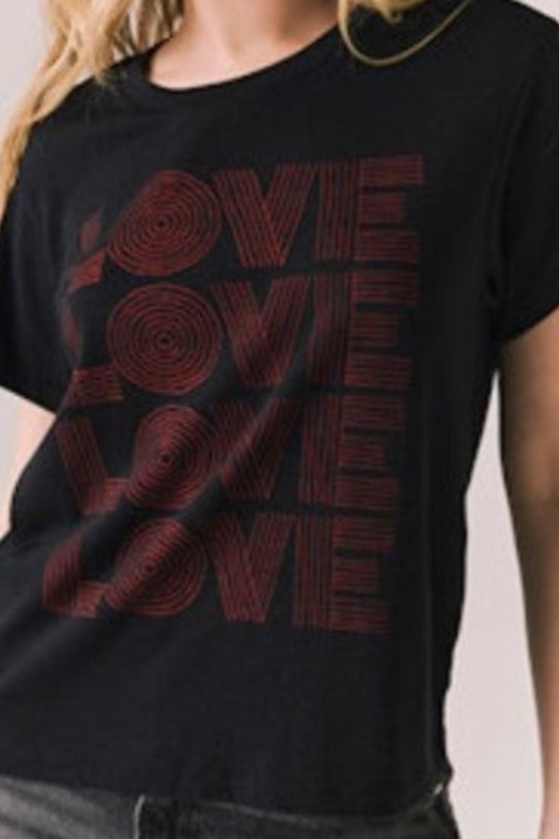 Woman wearing a black t-shirt with 'LOVE' printed in red.