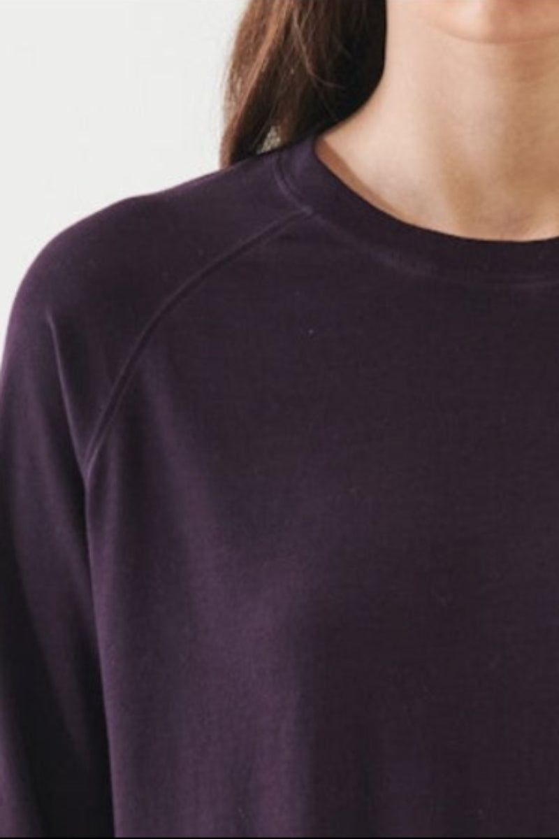 Close-up of a person wearing a dark purple sweater 