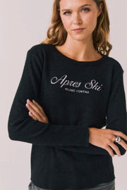 Woman wearing a black long-sleeve shirt with 'Apres Ski Milano Cortina' text 