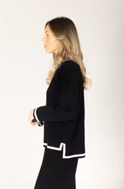 Woman wearing a black outfit with white trim. 
