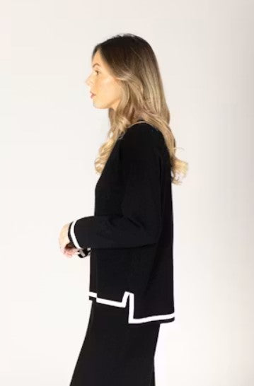 Woman wearing a black outfit with white trim. 