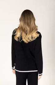 Woman wearing a black outfit with white trim. 