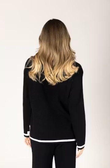 Woman wearing a black outfit with white trim. 