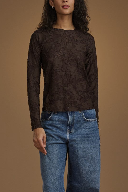 Women wearing brown long sleeve top with floral pattern. 