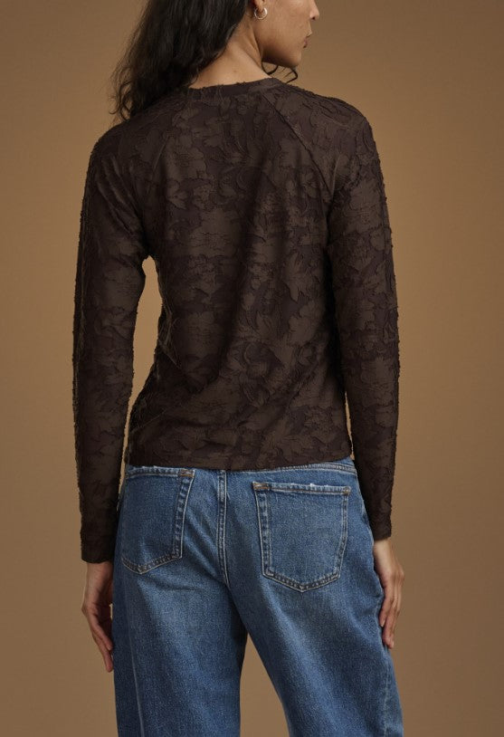 Women wearing brown long sleeve top with floral pattern. 