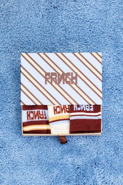 Three pairs of crew socks. One pair is light blue and white with dark red stripes and 'FRENCH' text.