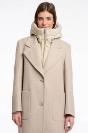 Woman wearing a beige coat with a matching scarf on a white background
