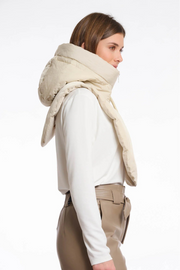Woman wearing a beige scarf and beige pants on a white background