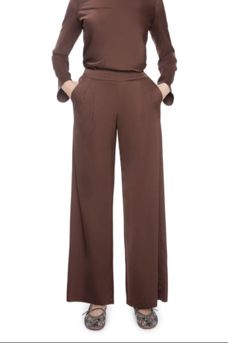 Woman wearing a brown satin set outfit on a white background