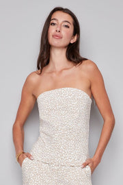 Woman wearing a strapless white and beige leopard print top