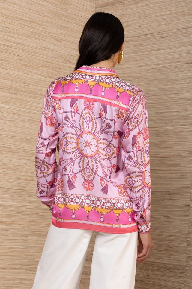 woman wearing a pink silk button down with rouching on the sleeves untucked