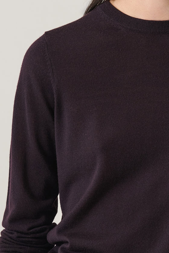 Close-up of a dark purple sweater on a plain background