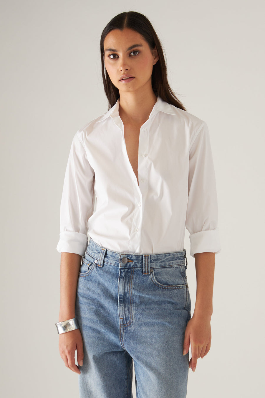 model wearing white button up collard dress shirt with cuffed sleeves 
