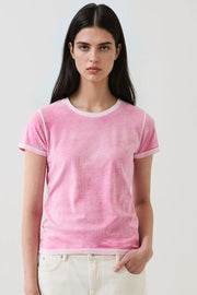 woman wearing a pink short-sleeve crewneck t-shirt with contrast trim paired with light-colored pants, front