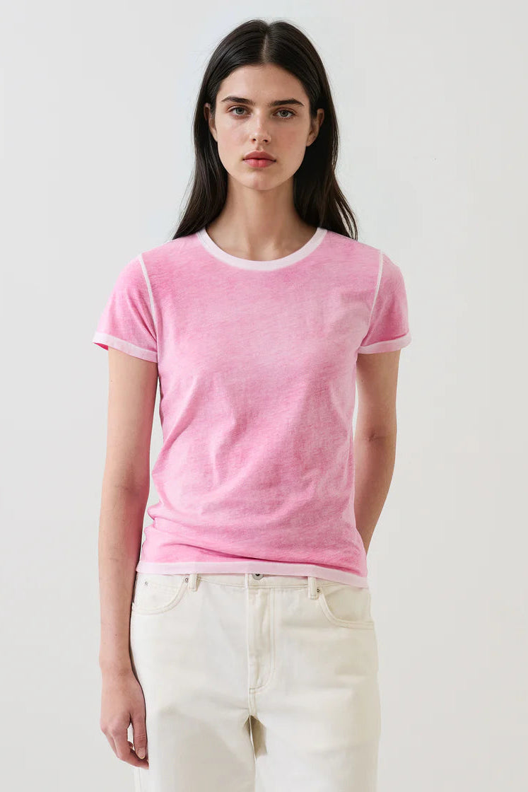 woman wearing a pink short-sleeve crewneck t-shirt with contrast trim paired with light-colored pants, front