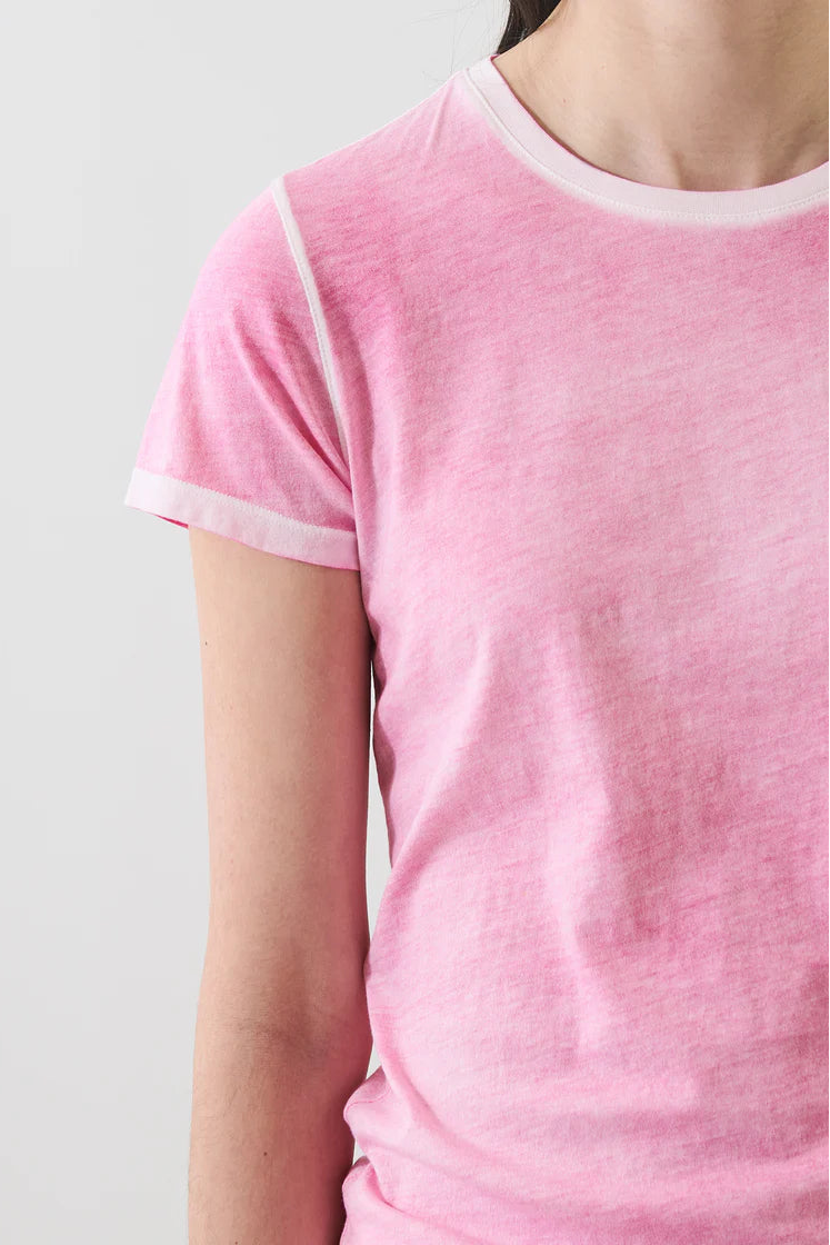 woman wearing a pink short-sleeve crewneck t-shirt with contrast trim paired with light-colored pants, detail
