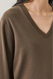Brown sweater worn by a person on a white background