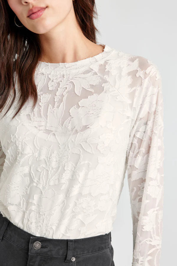 Front view of woman wearing an off white lace-like long sleeve