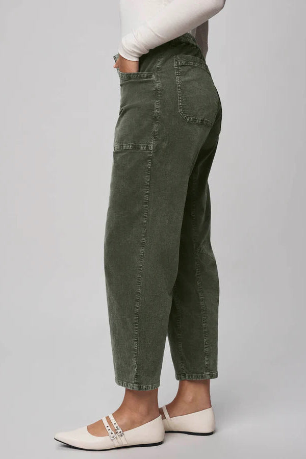 Person wearing olive green pants on a plain background