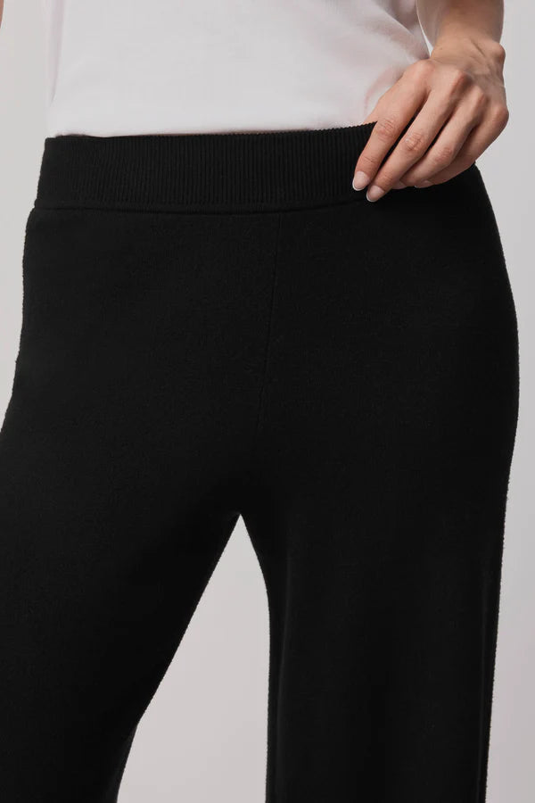 Black pants worn by a person on a light gray background