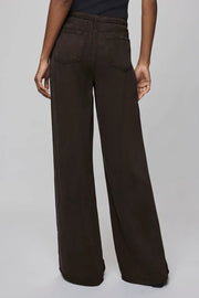 Brown wide-leg pants worn by a person on a gray background
