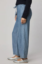 Woman wearing indigo wide leg pants with waist tie