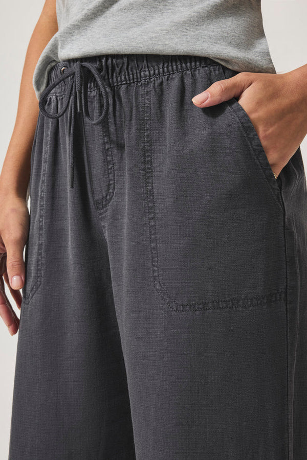 Person wearing dark gray wide-leg pants