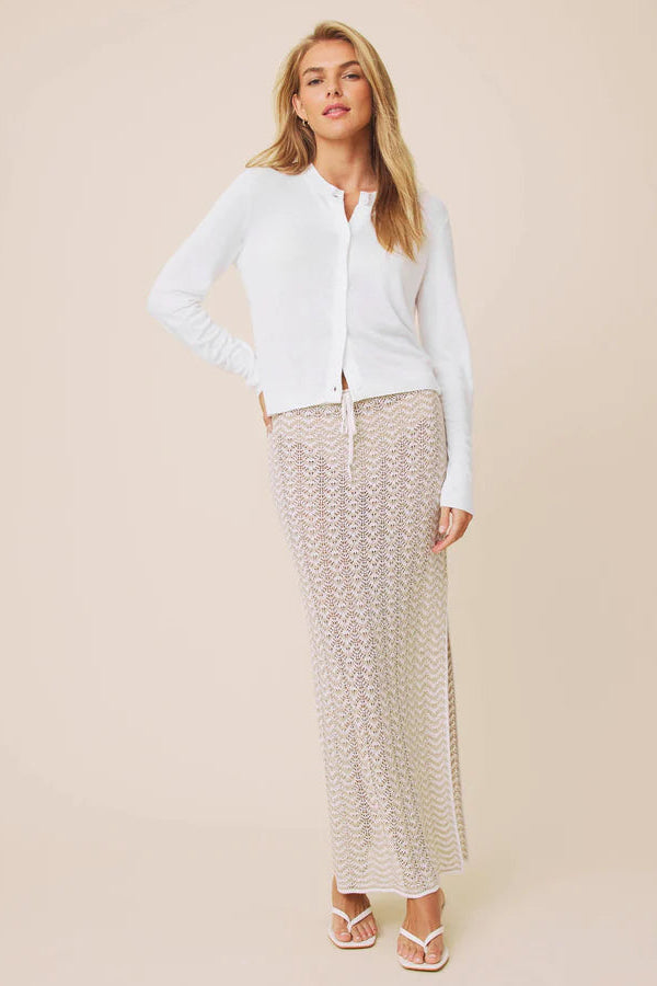 Woman wearing a white long-sleeve button up knit cardigan 