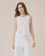 Woman wearing a white sleeveless crochet top 
