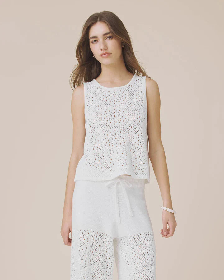 Woman wearing a white sleeveless crochet top 