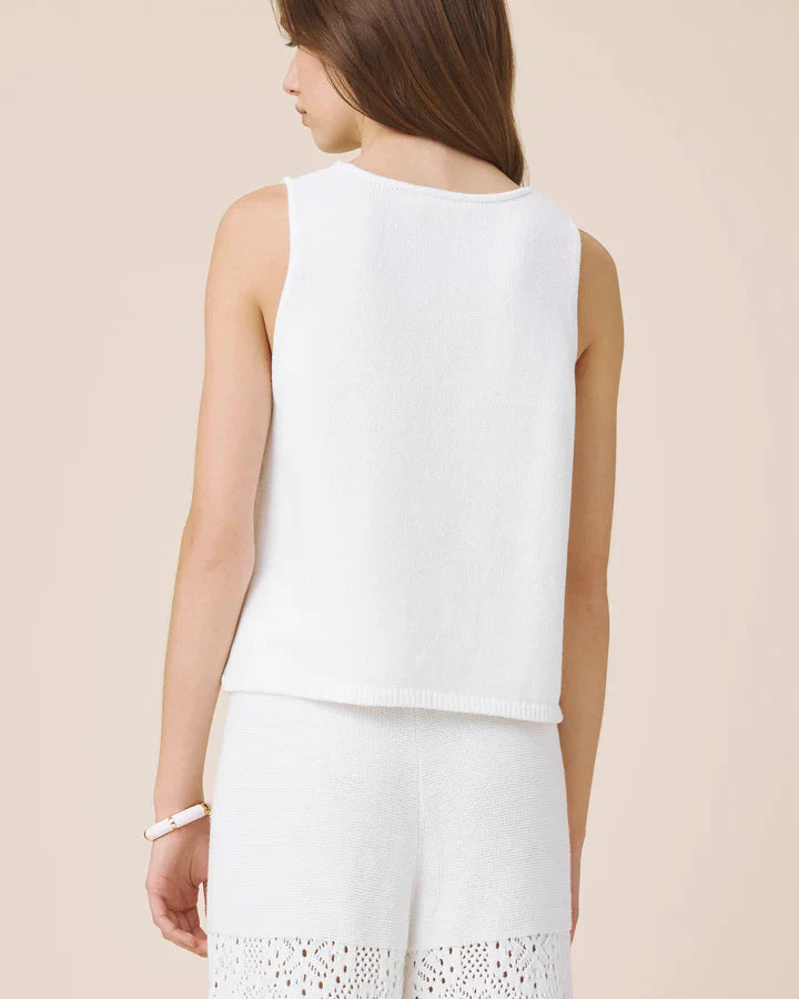 Woman wearing a white sleeveless crochet top 