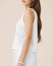 Woman wearing a white sleeveless crochet top 
