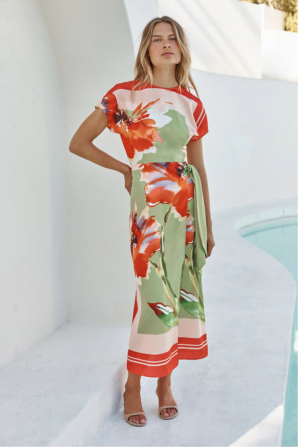 Woman wearing a boat neck short sleeve wrap waist scarf colorful floral dress 