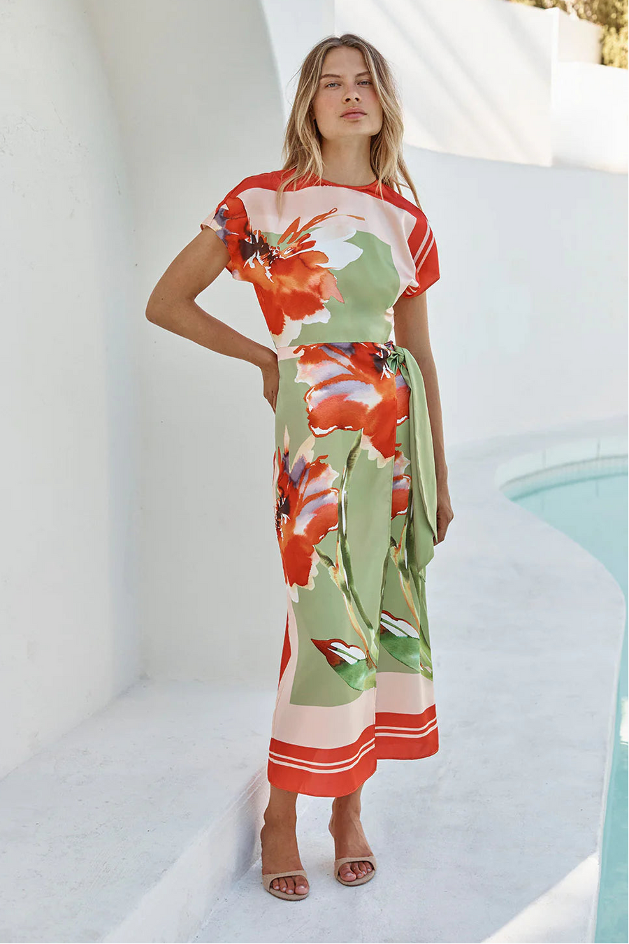 Woman wearing a boat neck short sleeve wrap waist scarf colorful floral dress 
