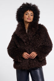 Woman wearing a brown faux fur jacket in chocolate brown. 