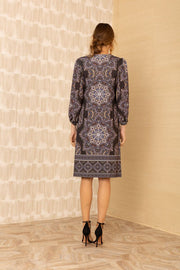 Back view of woman wearing patterned black v-neck long sleeve midi dress