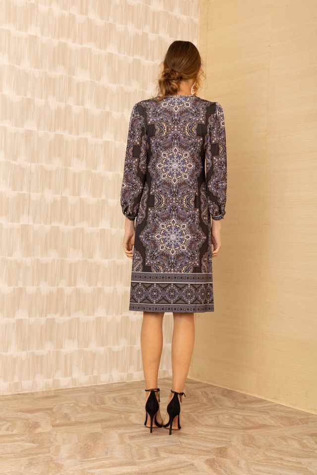 Back view of woman wearing patterned black v-neck long sleeve midi dress