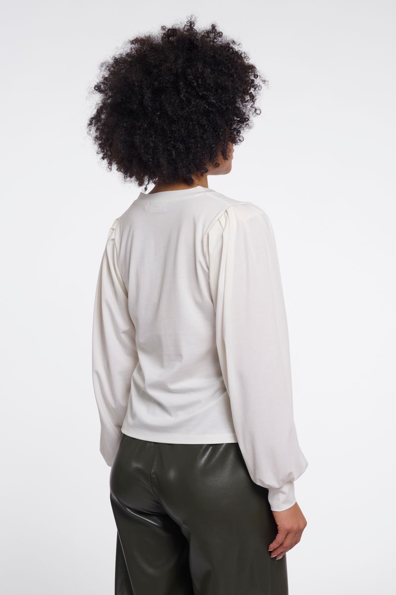 Woman wearing a white v-neck blouse. 