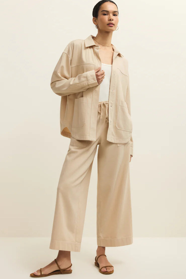 woman wearing a light beige twill collared button up jacket with matching pants