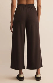 Dark brown wide-leg pants worn by a person on a beige background