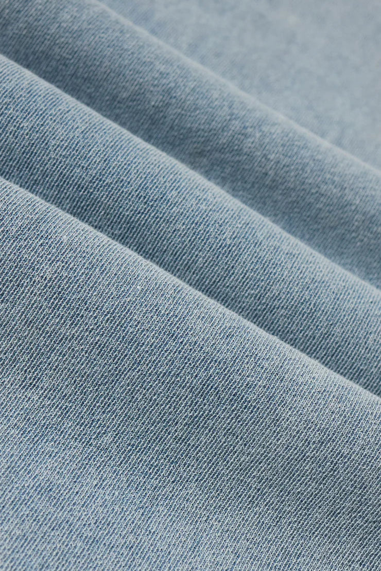 light blue wide leg denim pants with elastic waistband and front pockets, fabric detail view