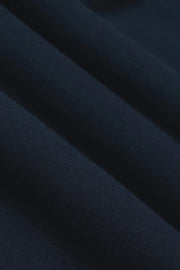 Woman wearing navy wide leg pants with drawstring waistband and contrast white side stripe, fabric detail view